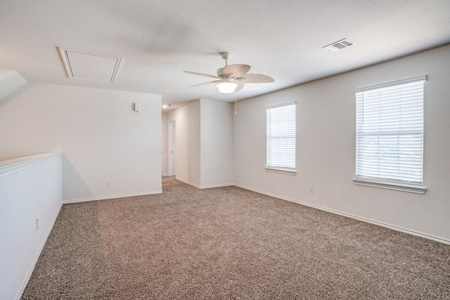 Spare room with attic access, carpet floors, a ceiling fan, and a textured ceiling | Image 9