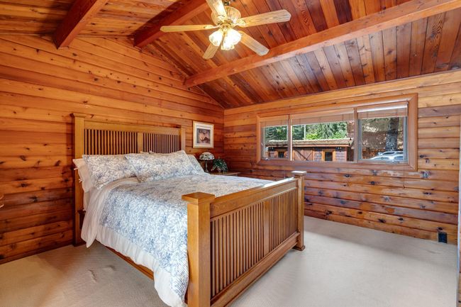 Bedroom featuring carpet, wood ceiling, wooden walls, and ceiling fan | Image 20