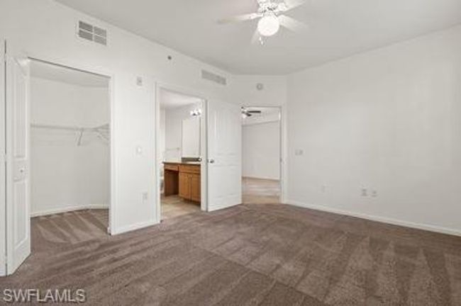 Unfurnished bedroom with a walk in closet, visible vents, baseboards, and carpet floors | Image 19