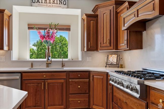Kitchen with a sink, light countertops, and stainless steel appliances | Image 17