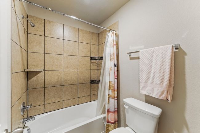 Full bath featuring toilet and shower / bathtub combination with curtain | Image 31