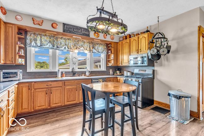 kitchen with stainless steel appliances, open shelves, light wood-style floors, and backsplash | Image 22