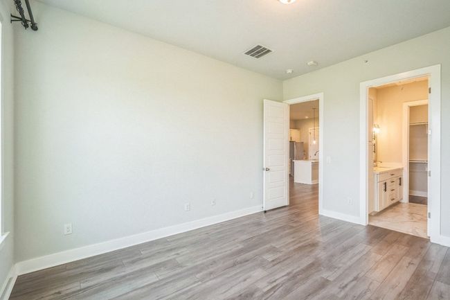 Unfurnished bedroom featuring light wood finished floors, baseboards, and ensuite bathroom | Image 13
