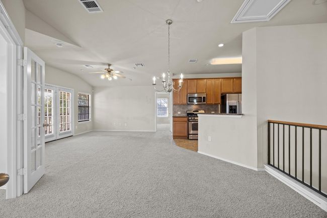 Living room featuring light carpet, vaulted ceiling, plenty of natural light, and visible vents | Image 8