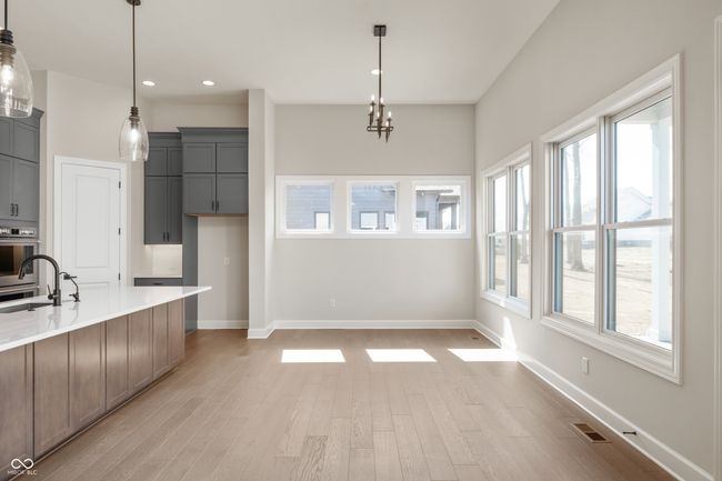 Dining area featuring light wood-style flooring and large windows with impressive natural light. | Image 8