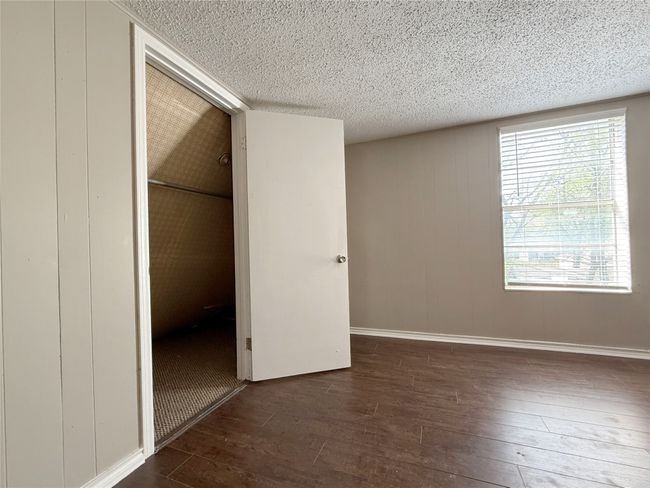 Unfurnished bedroom featuring a textured ceiling, a closet, baseboards, and hardwood / wood-style floors | Image 15