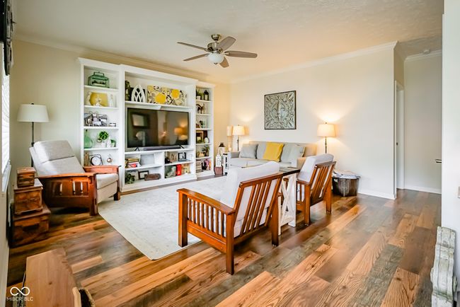 living area featuring ceiling fan, crown molding, and wood finished floors | Image 8