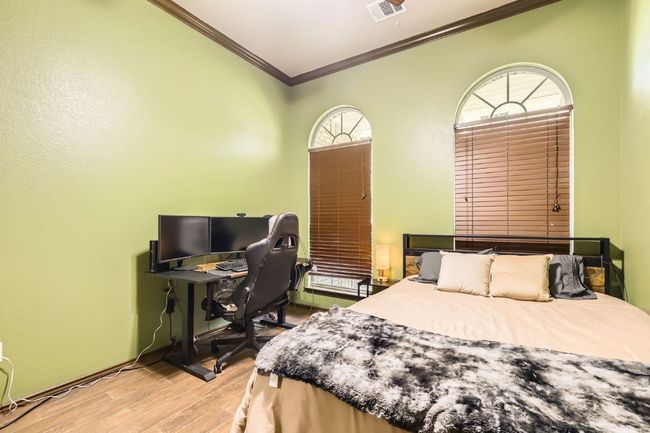 Bedroom featuring crown molding, wood finished floors, and an office area | Image 21