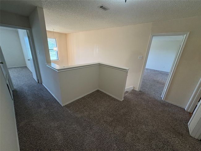 Hall featuring an upstairs landing, carpet, and a textured ceiling | Image 17