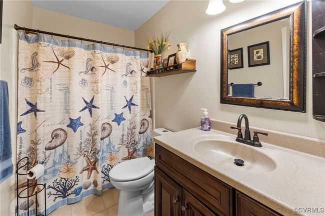 Full bath featuring vanity, tile patterned floors, toilet, and a shower with curtain | Image 25