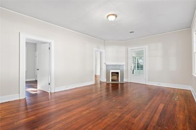 Unfurnished living room with crown molding, a fireplace, and dark hardwood / wood-style floors | Image 2