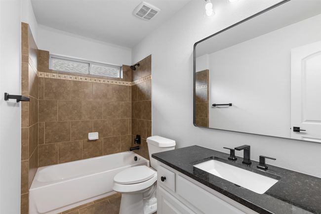 Full bath featuring vanity, toilet, visible vents, bathtub / shower combination, and tile patterned flooring | Image 34