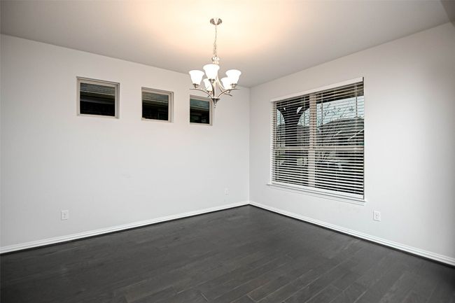 Unfurnished room featuring dark wood-style floors, baseboards, and an inviting chandelier | Image 22