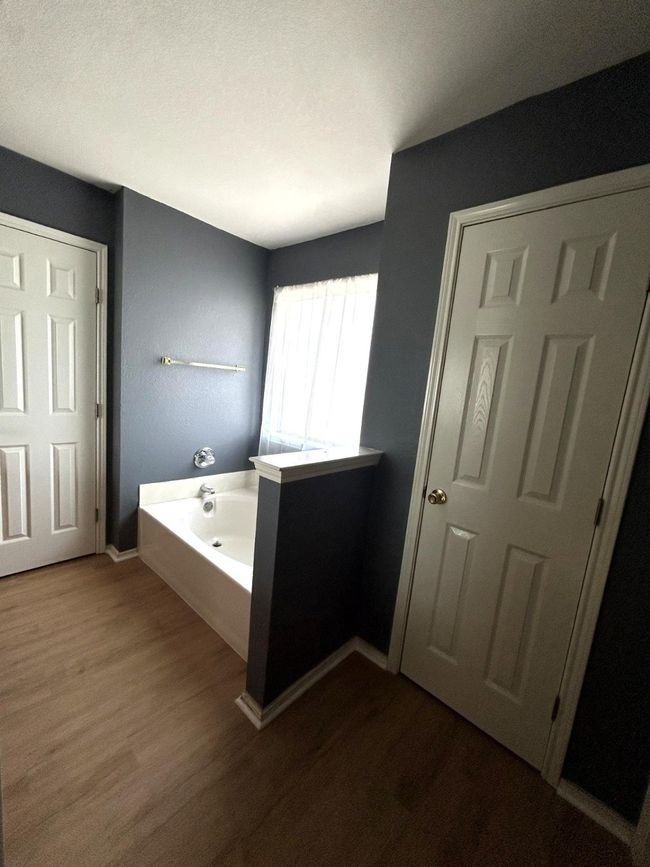 Bathroom featuring wood finished floors and a bath | Image 9