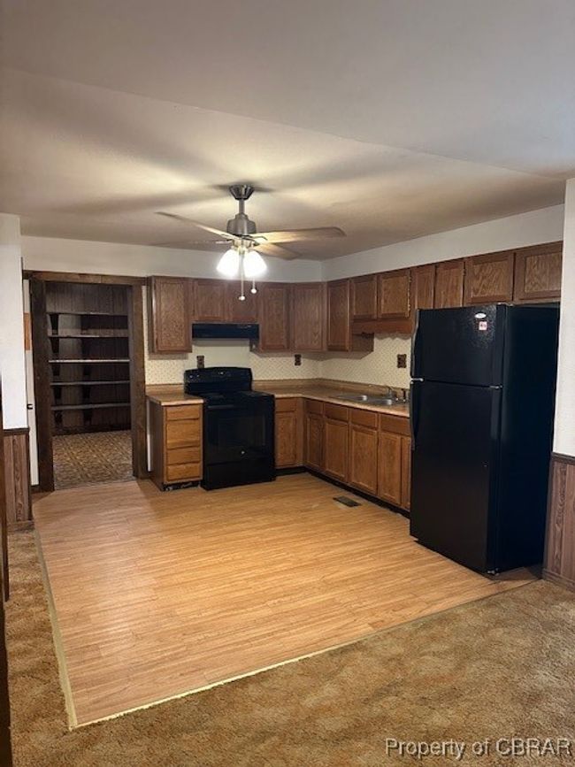 Kitchen with range, refrigerator, exhaust hood, a sink, and a ceiling fan | Image 18