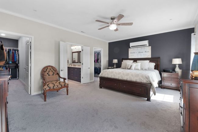 Primary Bedroom with crown molding, a spacious closet, a closet, and a wall mounted air conditioner | Image 12