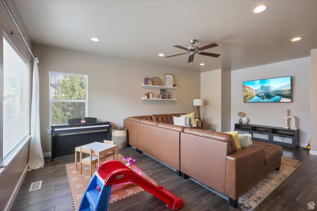 Living room featuring a ceiling fan, baseboards, dark wood-style flooring, visible vents, and recessed lighting | Image 16