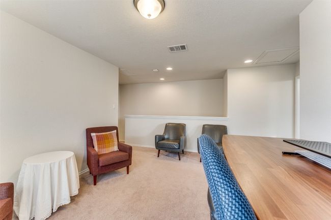 Heading upstairs, we find the open concept second living area that is used for a fully functional office in this setting. | Image 18