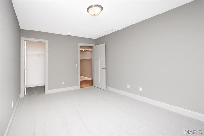 Upstairs bedroom with a spacious walk-in closet, baseboards, and light colored carpet | Image 31