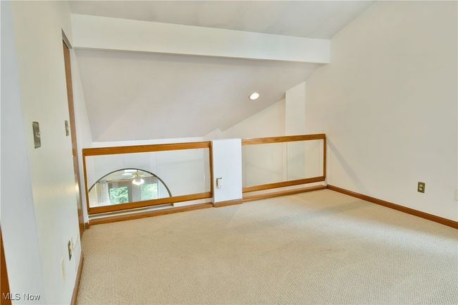 Carpeted spare room featuring vaulted ceiling and baseboards | Image 25