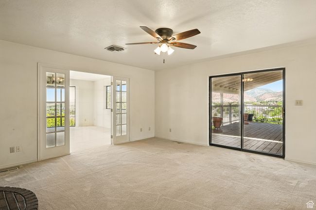 Unfurnished room with healthy amount of natural light, ceiling fan, and light colored carpet | Image 7