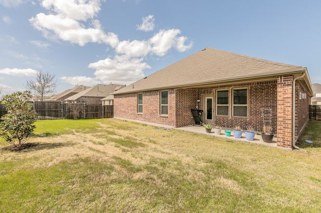 Back of house with a patio area, a yard, a fenced backyard, and brick siding | Image 4