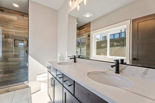 Bathroom featuring double vanity, toilet, a shower stall, tile patterned floors, and recessed lighting | Image 23
