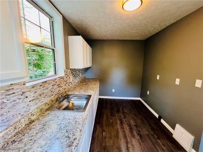 Kitchen with white cabinets, new counters, plenty of natural light, and stainless sink | Image 3