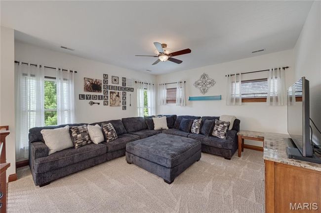 Living room with light colored carpet and ceiling fan | Image 28