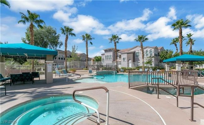 Community pool with a residential view, a hot tub, a patio area, and fence | Image 24