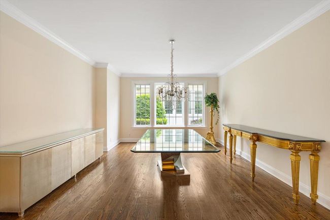 Unfurnished dining area featuring a chandelier, ornamental molding, baseboards, and dark wood-type flooring | Image 7