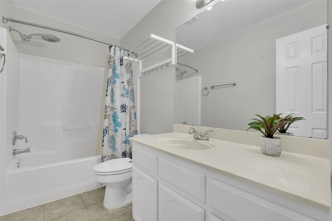 Bathroom featuring shower / bathtub combination with curtain, vanity, and tile patterned flooring | Image 19