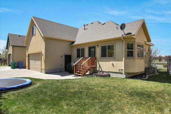 Back of house with stucco siding, roof with shingles, fence, and a yard | Image 28
