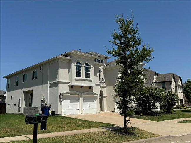 Mediterranean / spanish-style house with stucco siding, an attached garage, driveway, and a front lawn | Image 10