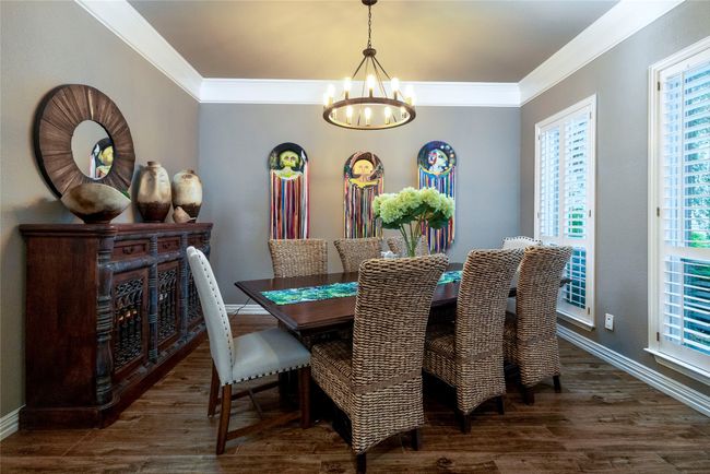 Dining room featuring crown molding and plantation shutters. | Image 5