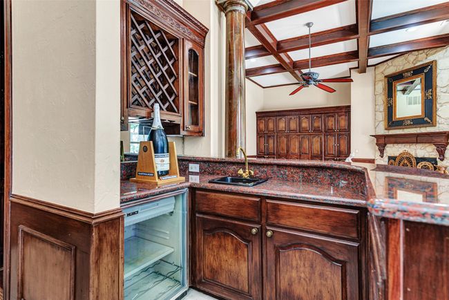 This charming wet bar sits between the kitchen and the family room! Counters to match the kitchen, plus wine storage and built-in beverage fridge. You'll be ready to party anytime! | Image 17