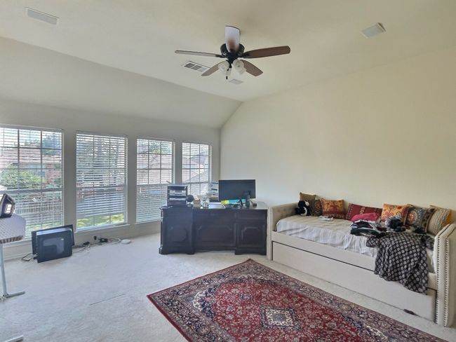 Carpeted bedroom featuring multiple windows, vaulted ceiling, and a ceiling fan | Image 8