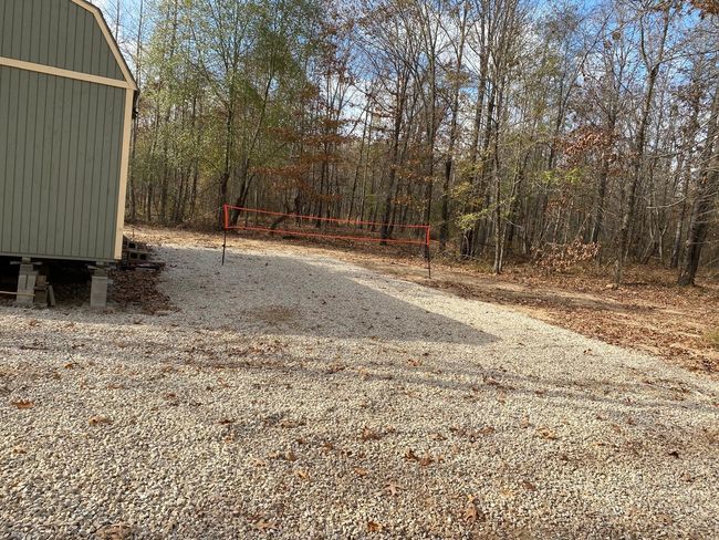 View of yard featuring volleyball court and a view of trees | Image 12