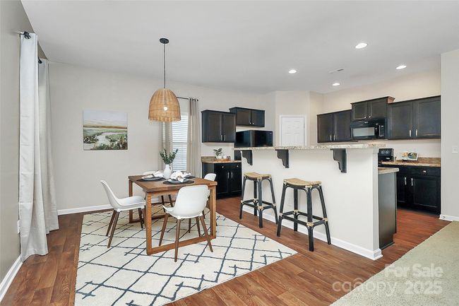 Open dining/kitchen space with transition via bar area suitable for plenty of guests. | Image 10