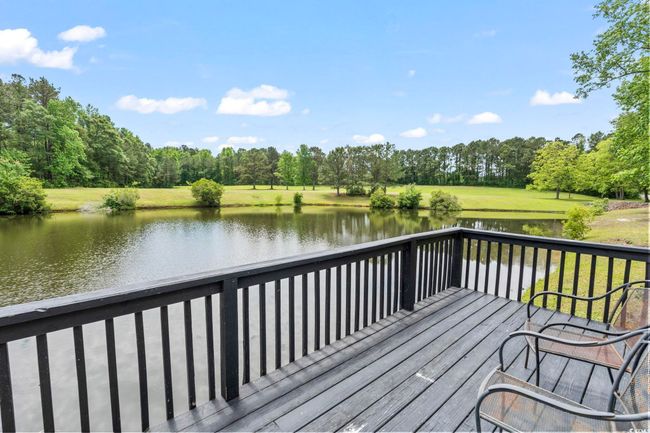 Deck featuring a water view, view of wooded area, and a lawn | Image 33