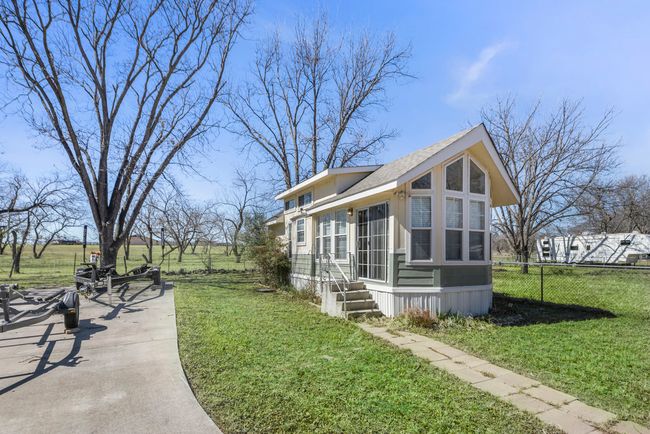 View of property exterior featuring a yard and fence | Image 32