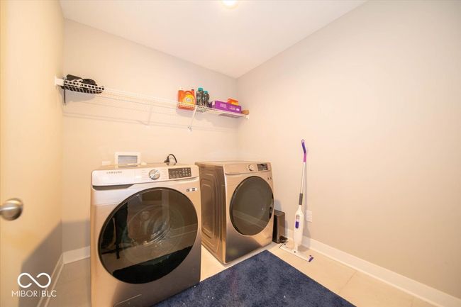 washroom with washing machine and dryer and tile patterned floors | Image 16