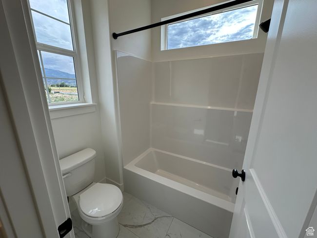 Bathroom featuring marble look tile flooring and bathing tub / shower combination | Image 20
