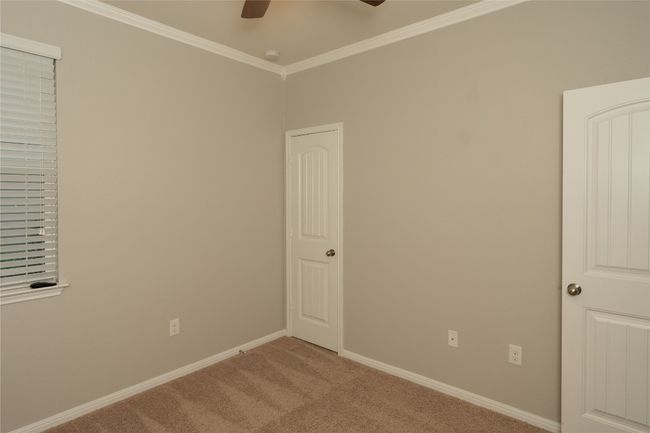 Empty room with ceiling fan, ornamental molding, carpet, and baseboards | Image 17