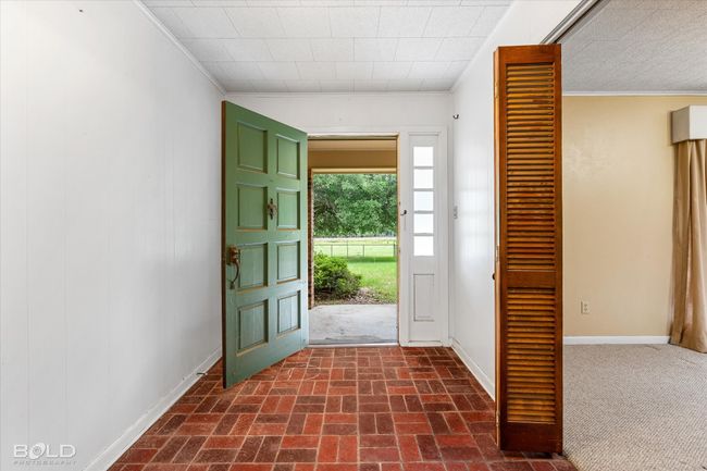 Entrance foyer with crown molding, baseboards, and brick patterned flooring | Image 5