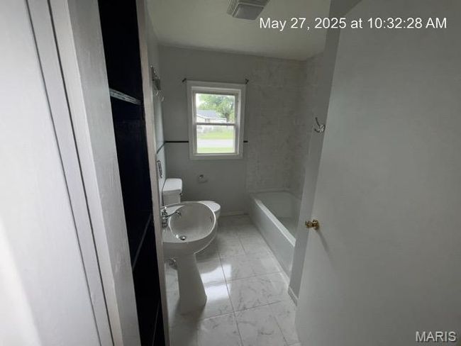 Full bath with marble look tile flooring, toilet, and baseboards | Image 12