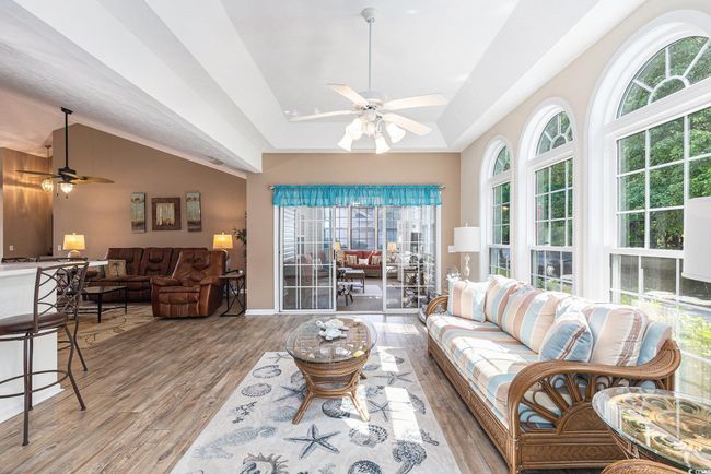 Living room featuring ceiling fan, healthy amount of natural light, wood finished floors, and vaulted ceiling | Image 14