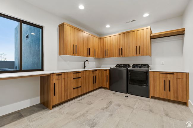 Washroom featuring a sink, separate washer and dryer, cabinet space, visible vents, and recessed lighting | Image 40