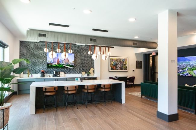 Bar with tasteful backsplash, light wood-type flooring, visible vents, and hanging light fixtures | Image 20