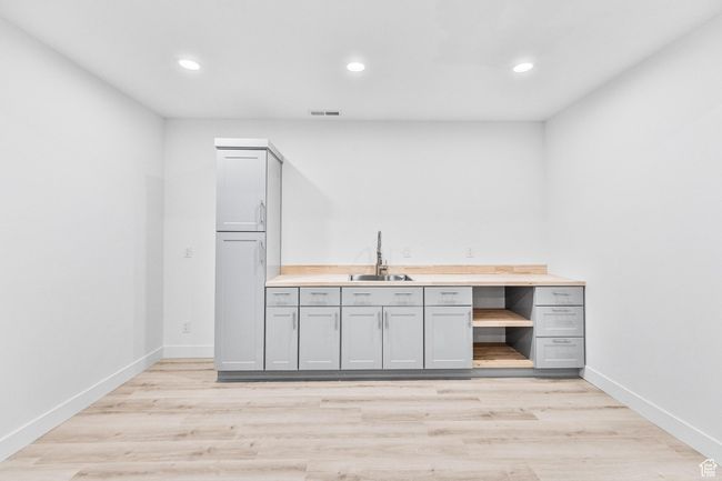 Bar featuring recessed lighting, light wood-style flooring, baseboards, and a sink | Image 41